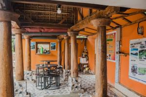 ein Restaurant mit Säulen und einem Tisch in einem Gebäude in der Unterkunft Roby Homestay in Kuta Lombok