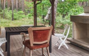 una mesa de madera y sillas en un porche en 2 Bedroom Pet Friendly Home In Popowo-letnisko 