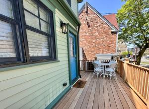 a wooden porch with two chairs and a table on it at 10 Fair H in Newport