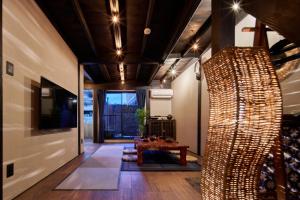 un soggiorno con un tavolo e un soffitto con luci di おやど紀伊国屋 丸山町 庭 a Nagasaki