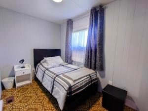 ein kleines Schlafzimmer mit einem Bett und einem Fenster in der Unterkunft Red Island Cozy Casa in Summerside