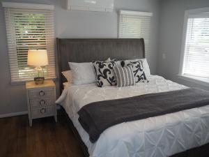 una camera da letto con letto, cuscini e lampada di Lorlee - A Large And Luxurious Lakefront Cottage! a Woodland Beach
