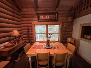 een houten eetkamer met een tafel en een raam bij 3-Level Log Cabin near Silverwood - Tranquil in Spirit Lake