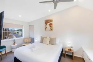 a bedroom with a large white bed and a window at Reflections Bermagui - Holiday Park in Bermagui