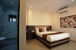 a bedroom with a bed and a bathroom with a shower at MEGH INN in Navi Mumbai