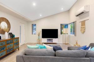 sala de estar con 2 sofás y TV de pantalla plana en Aqua21 @ Cape Villas Dunsborough, en Dunsborough