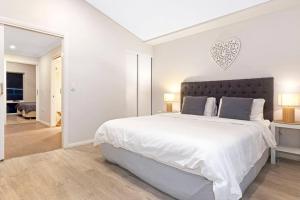 1 dormitorio blanco con 1 cama grande y cabecero cardiaco en Aqua21 @ Cape Villas Dunsborough, en Dunsborough