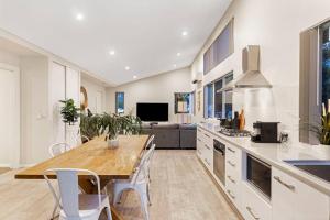 eine Küche mit Tisch und Stühlen und einer Couch in der Unterkunft Aqua21 @ Cape Villas Dunsborough in Dunsborough