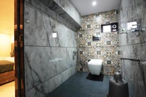 a bathroom with a toilet and a stone wall at MEGH INN in Navi Mumbai