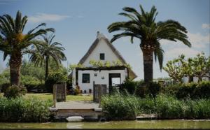 una pequeña casa blanca con palmeras delante en Loft C El Ramellet, en Alginet