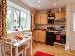 a kitchen with a wooden table and a table and chairs at Cupid's Cottage in Bessingby
