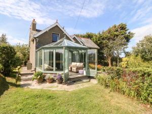 a green greenhouse in the yard of a house at Rhianfa in Aberdaron