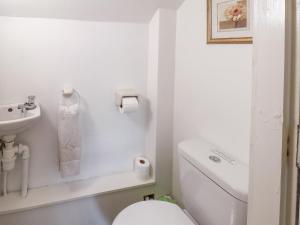 a white bathroom with a toilet and a sink at The Mews in Bridlington
