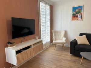 sala de estar con TV y silla en Duplex climatisé proche port Toulon en Toulon