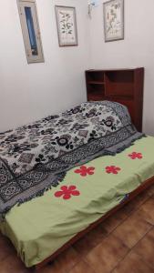 Una cama con edredón en un dormitorio en Botanical house en San Miguel de Tucumán