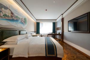 a bedroom with a large bed and a flat screen tv at Nostalgia S Hotel Shanghai Railway Station in Shanghai