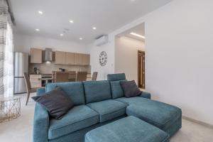 圣朱利安斯St Julians Apartment的带蓝色沙发的客厅和厨房