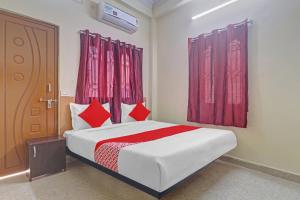 a bedroom with a bed with red curtains and a door at 80983G RBS Square Langer Houz in Haidar Sāhibgūda