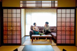 熱海市にある熱海温泉 湯宿一番地の二人の女性が部屋のソファに座っている