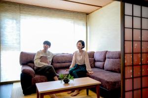 un homme et une femme assis sur un canapé dans l'établissement Yuyado Ichibanchi, à Atami