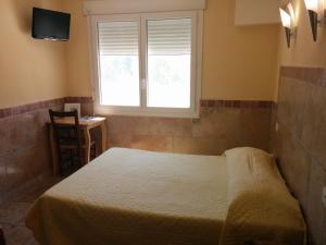 a bedroom with a bed and a window and a table at Hôtel Restaurant l'Agachon in Albaron