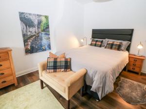 a bedroom with a large bed and a chair at 2 Carr Farm Close in Glossop