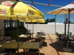 a group of tables and umbrellas at a restaurant at Hôtel Restaurant l'Agachon in Albaron