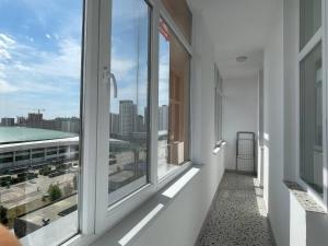 a balcony with windows with a view of a city at Город Ботанический in Taldykolʼ