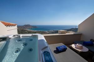 a bath tub sitting on top of a balcony with the ocean at Stefanos Village Hotel in Plakias