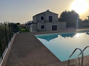 a swimming pool with a house in the background at Villa Simo in Altavilla Milicia