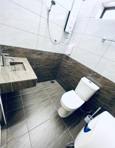 a bathroom with a white toilet and a sink at SingHome Holiday House in Mersing