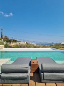 米克諾斯城的住宿－Abelos Mykonos，游泳池旁设有2把躺椅和躺椅