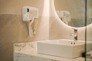 a bathroom with a sink and a phone on the wall at PLEIKU HIGHLANDS BOUTIQUE HOTEL in Plei Brel (2) +60 photos