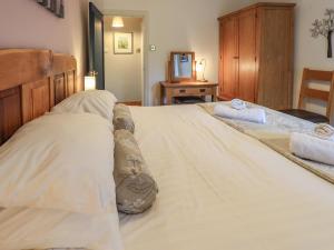 a bedroom with a large bed with two towels on it at Tullythwaite Garth in Crosthwaite