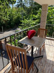 a table and chairs on a balcony with a red pillow at Riambel Paradise Inn Primary Apartment in Riambel