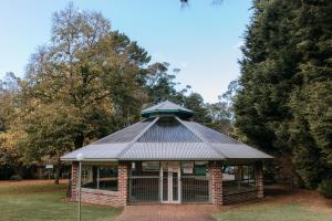 a building with a metal roof in a park at Federation Gardens & Possums Hideaway in Blackheath