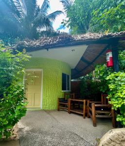 a building with a door and a table and benches at Victory Seaside Home in Bantayan Island