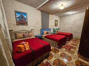 a room with two beds with red covers in it at Casa Miranda in Antigua Guatemala