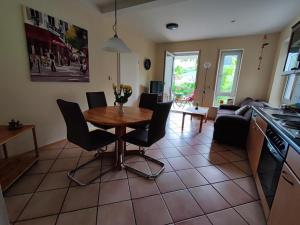 a kitchen and living room with a table and chairs at Ferienwohnung "Dorfblick" in Leinsweiler