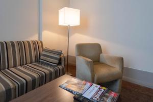 ein Wohnzimmer mit einem Sofa und einem Stuhl in der Unterkunft Hotel am Großen Waisenhaus in Potsdam