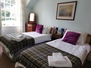 two beds sitting next to each other in a bedroom at Upper West Wing Flat - Tarvit in Cupar