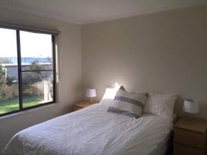 uma cama branca num quarto com uma janela em Airy Beach Escape in Ventnor em Ventnor