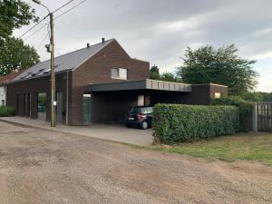 una casa de ladrillo con un coche aparcado en el garaje en Prachtige gastsuite in Ranst "Studio 34" en Ranst