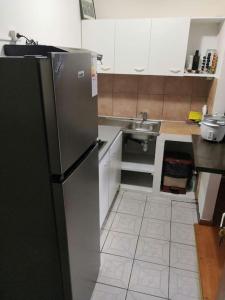 La cuisine est équipée d'un réfrigérateur en acier inoxydable et d'un évier. dans l'établissement Appartement idéalement situé, à Saint-Denis