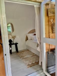 ein kleines Schlafzimmer mit einem Bett und einem Tisch in der Unterkunft Hofstede klein Rozendaal, Tuinhuis in Asch