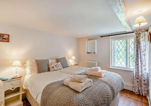 a bedroom with a bed with two towels on it at Corner Cottage - Kent in Benenden