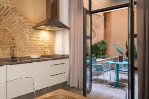 eine Küche mit weißen Schränken und einem blauen Tisch in der Unterkunft Suites Maestranza - Herrería by Magno Apartments in Sevilla