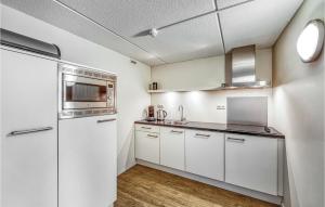 a kitchen with white cabinets and stainless steel appliances at Amazing Apartment In Schiermonnikoog in Schiermonnikoog