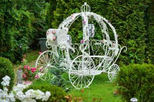 a white carriage in the middle of a garden at Casa Daniel in Bran