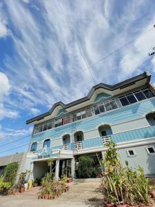 un edificio azul con ventanas y plantas en Jupiter Homestay, en Cabanatúan